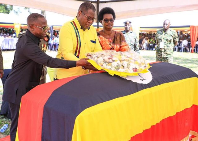 Oboth-Oboth who represented President Museveni lays a wreath at the casket