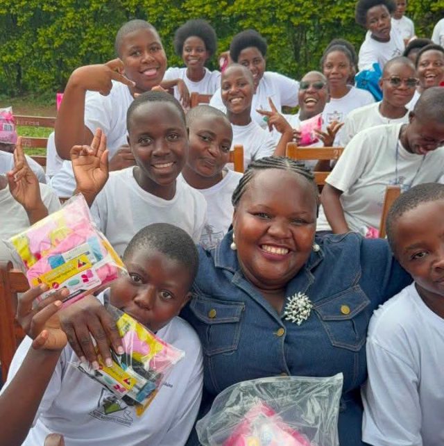 Hon Sarah Itungu Masereka pose for a picture with students of St Theresa Girls Nsenyi